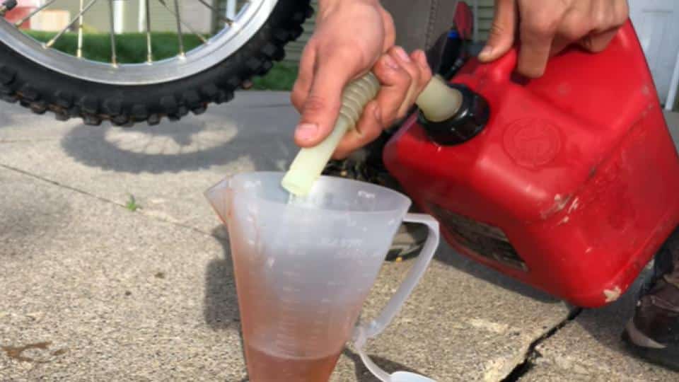 pouring gasoline into a measuring pitcher