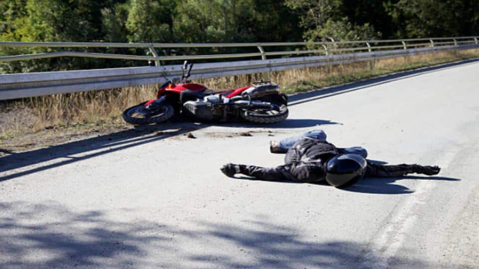 motorcycle accident with rider lying on pavement