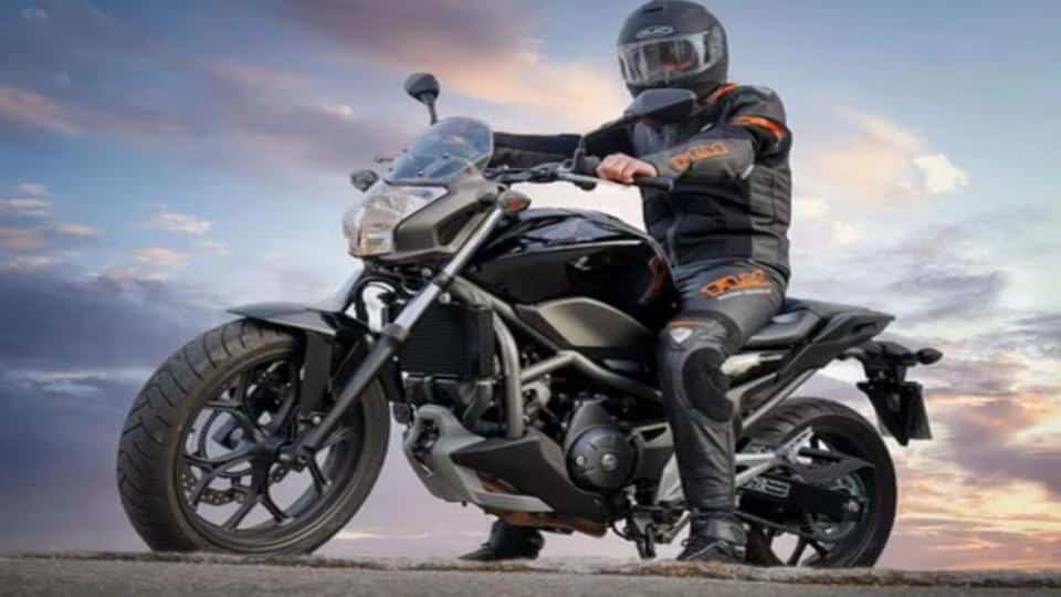 man riding a motorcycle with a cloudy sky