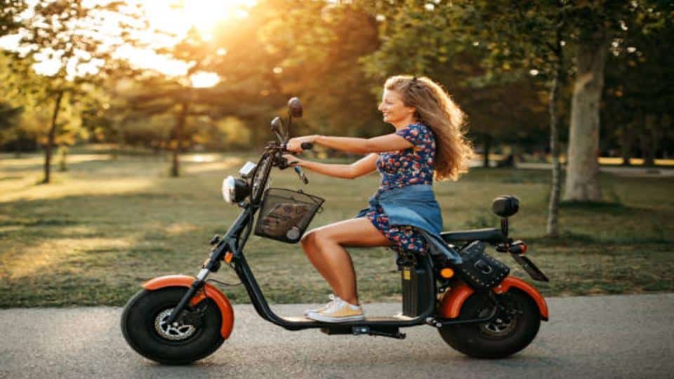 woman riding a moped scooter